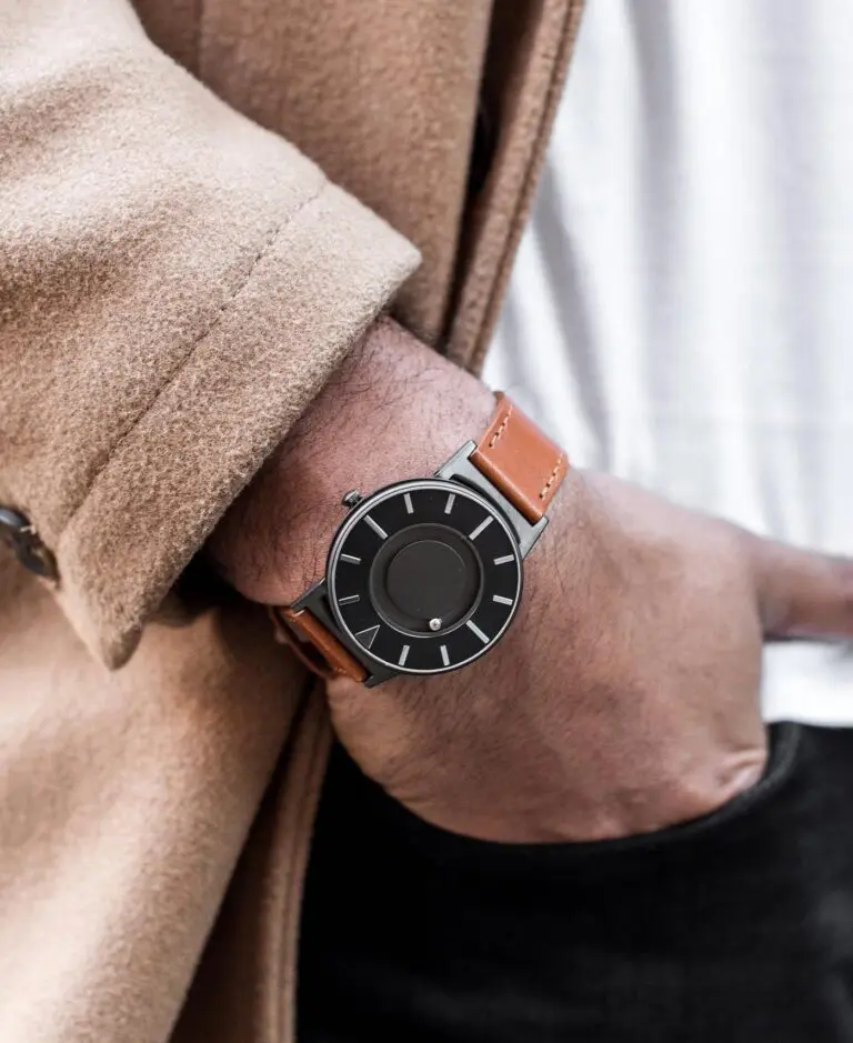 Man's hand and and wrist, wearing a timepiece designed for the visually impaired. 